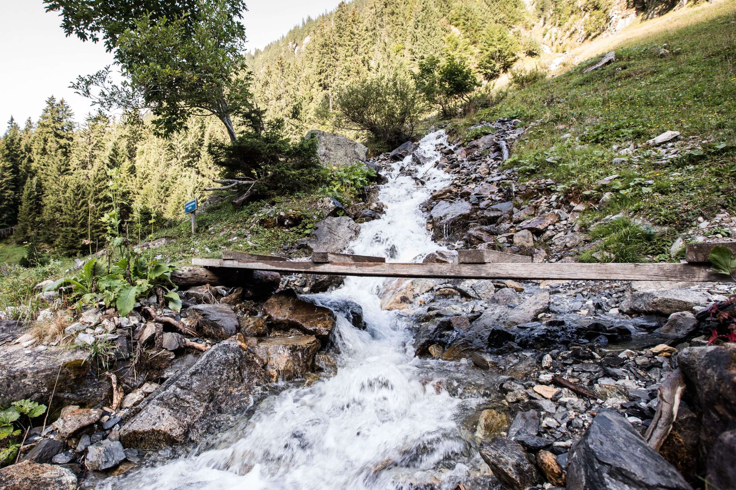 Mountain stream with bridge The mountain stream flows unstoppably. A small bridge leads over the stream into the rear Lauterbrunnen valley.