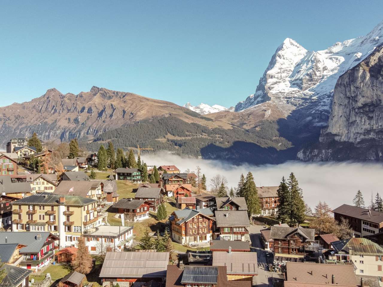 Le village de Müren est accueilli par les sunstrals. Au lieu de la vallée de Lauterbrunnen, c'est la mer de brouillard qui est visible. L'Eiger et le Mönch, couverts de neige, sont visibles en arrière-plan.