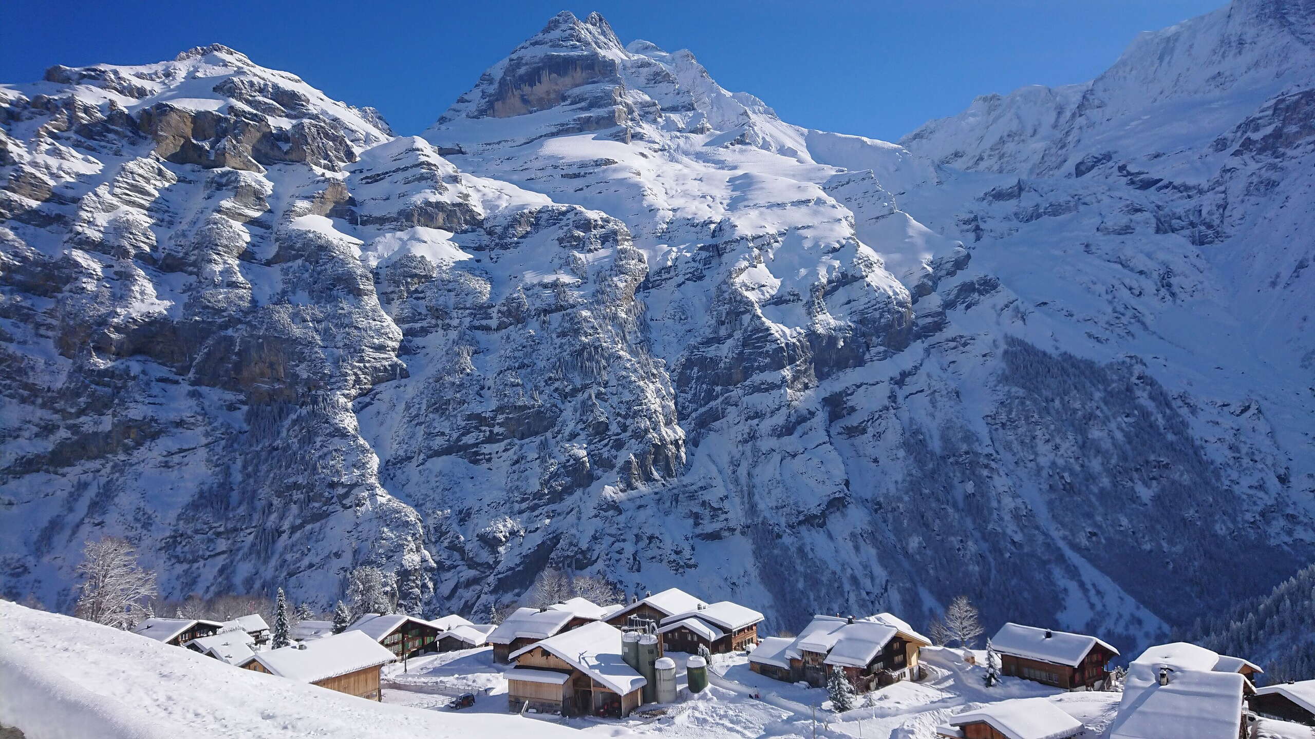 Verschneites Gimmelwald vor einem massiven Bergpanorama.