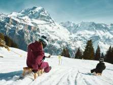 Zwei Personen sind mit dem Schlitten auf dem Bob Run in Mürren unterwegs.