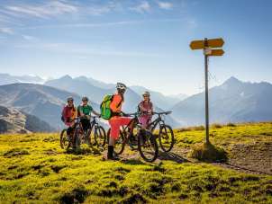 Les cyclistes regardent le panneau indicateur et profitent de la vue depuis le Hasliberg. Le panorama offre une vue estivale sur le paysage montagneux.