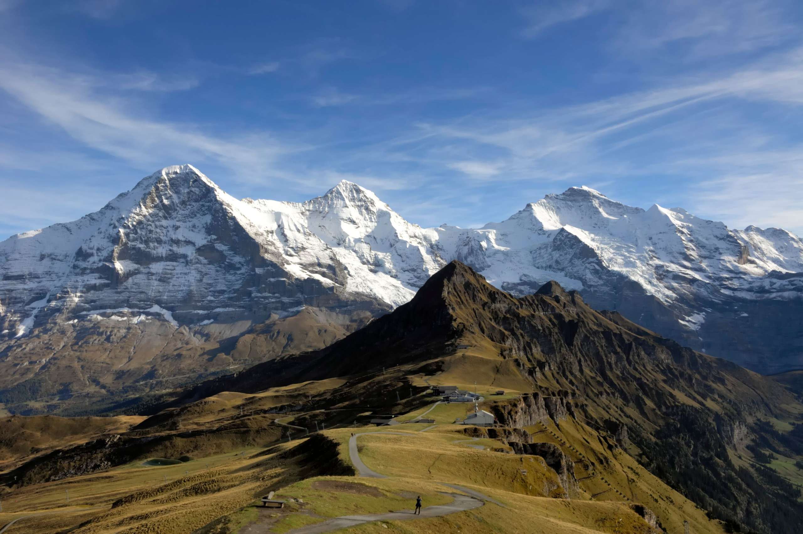View Männlichen View of the summery Männlichen with the snow-covered triumvirate of the Eiger, Mönch and Jungfrau in the background.
