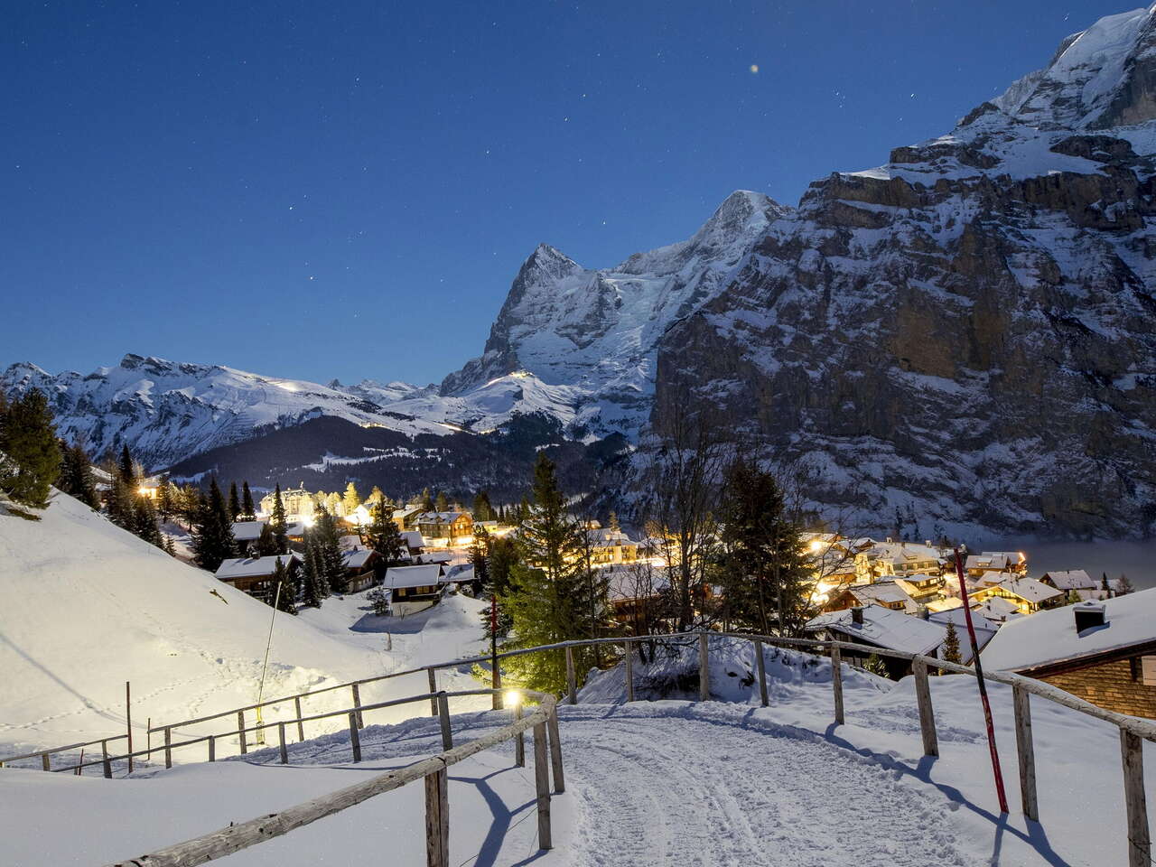 Snow-covered walk in Mürren at night. The path offers views of the Eiger, Mönch and Jungfrau.